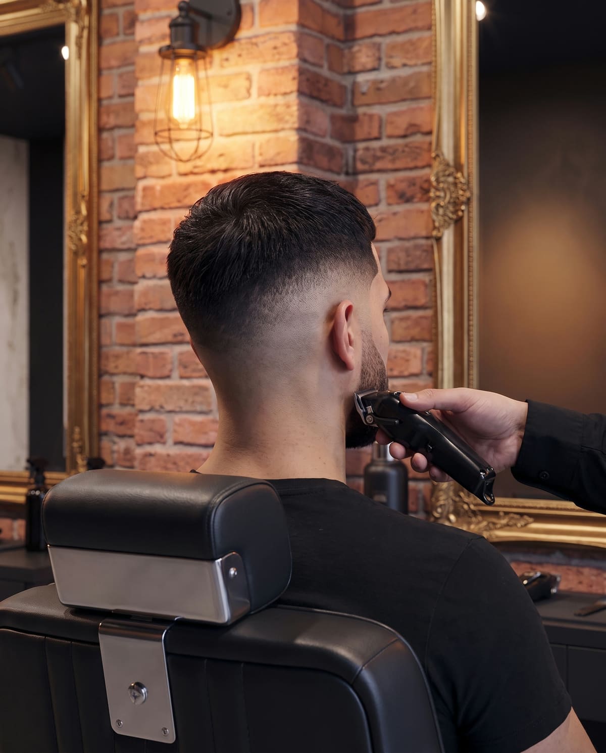 Barbearia Trezentos: degradê finalizado na cadeira, com a máquina ainda na mão do barbeiro